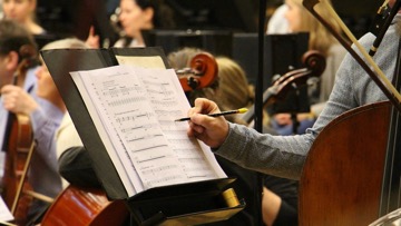 An image of a composer working on a score